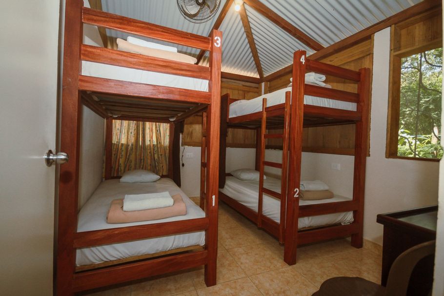 Una habitación con cuatro literas y un ventilador en el techo.