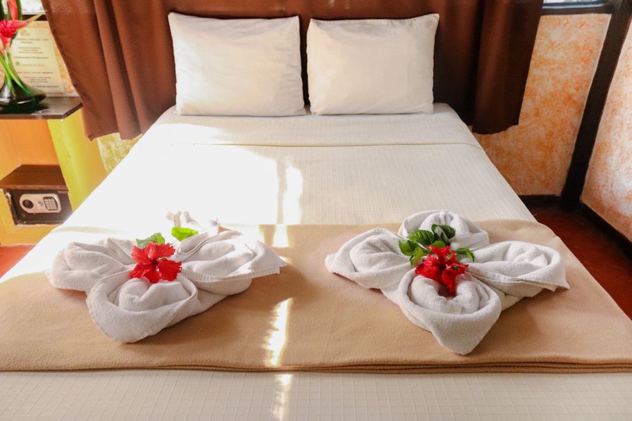 Una cama decorada con toallas y flores en una habitación de hotel.
