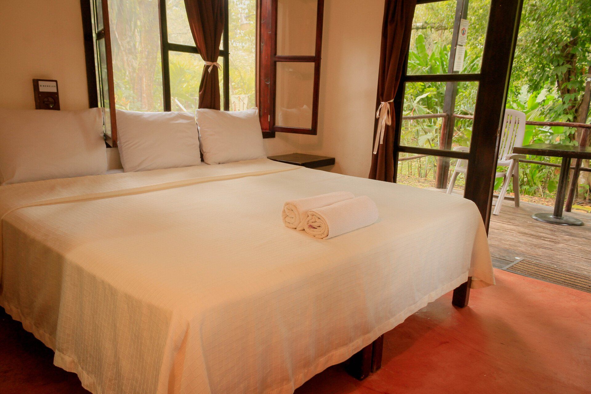 Un dormitorio con una cama y una ventana con árboles al fondo.
