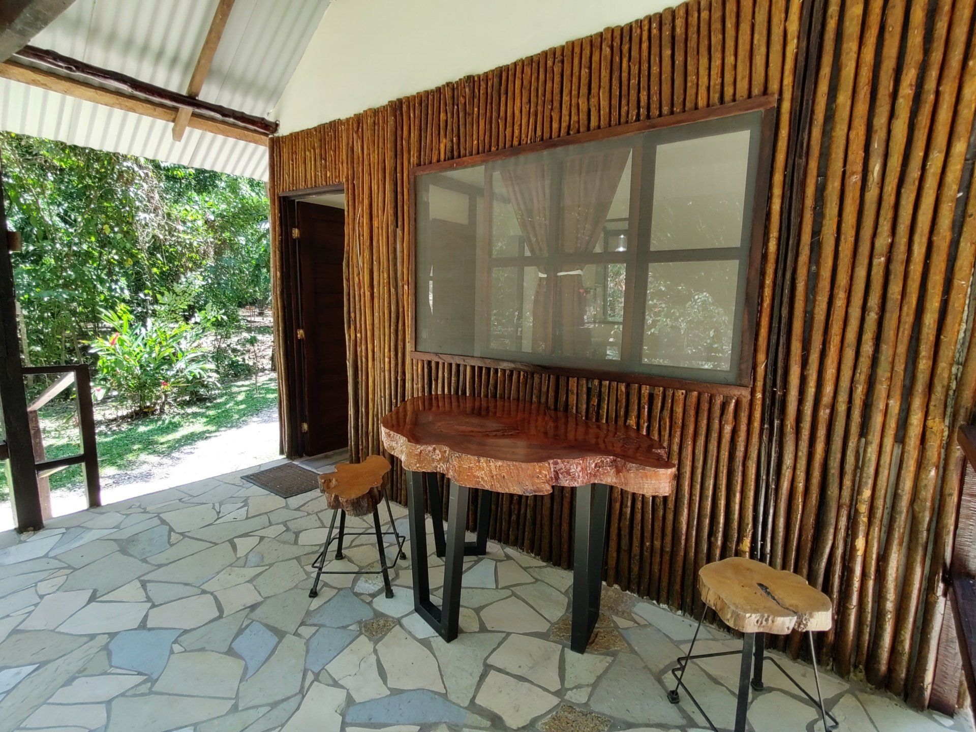 Un edificio de madera con una mesa y sillas delante de él.