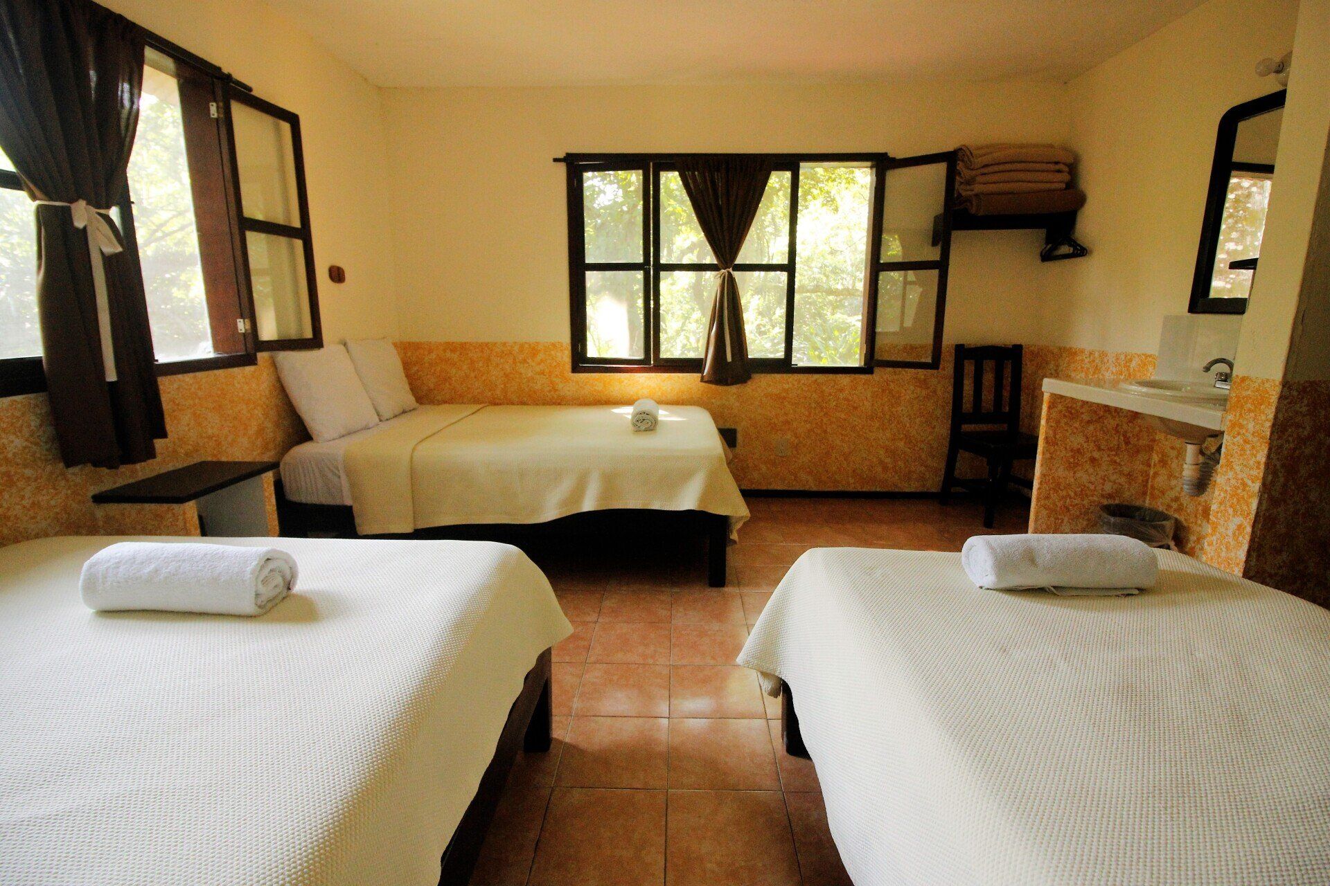 Una habitación de hotel con dos camas y un lavabo.