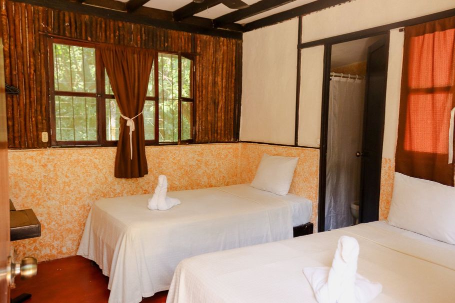 Una habitación de hotel con dos camas y una ventana.