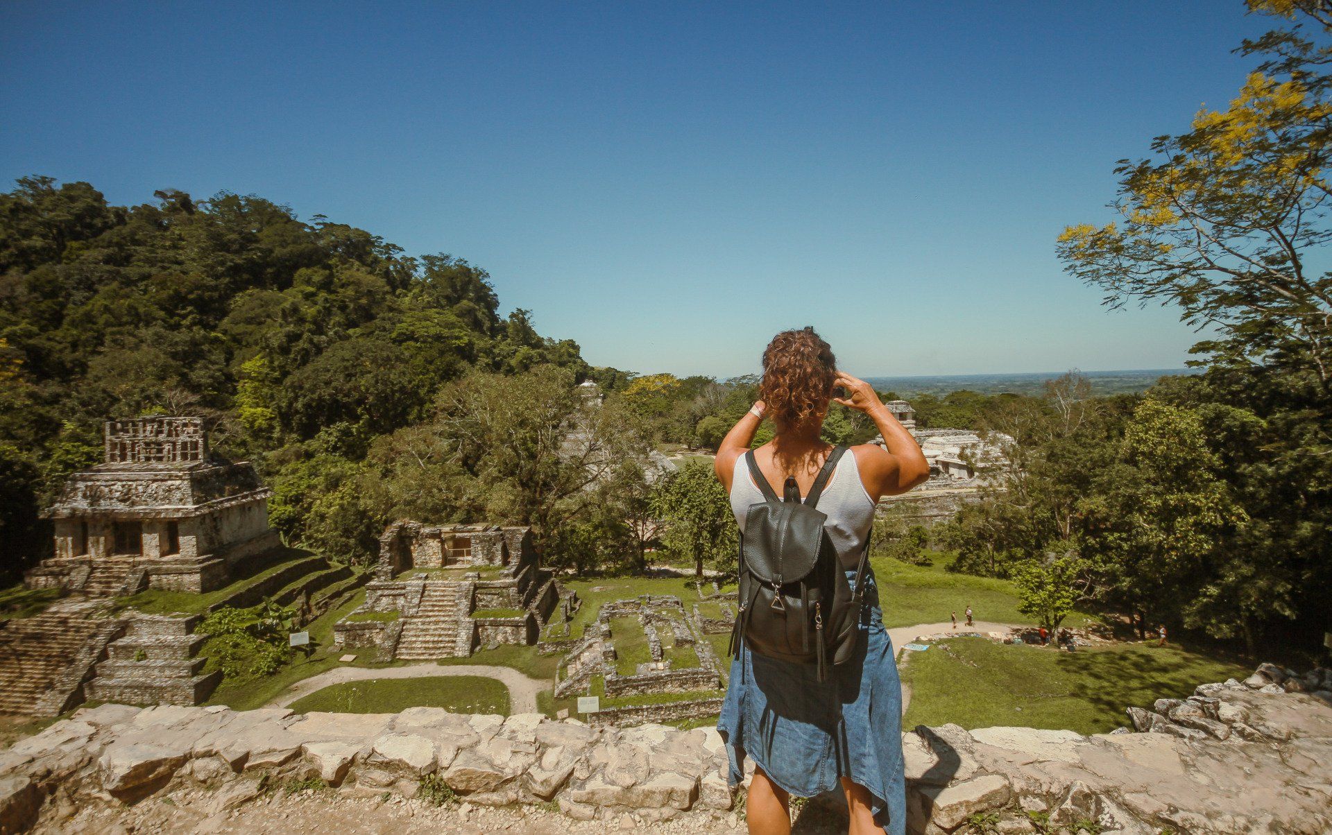 Turista tomando una foto a las pirámides de la Zona Arqueológica de Palenque
