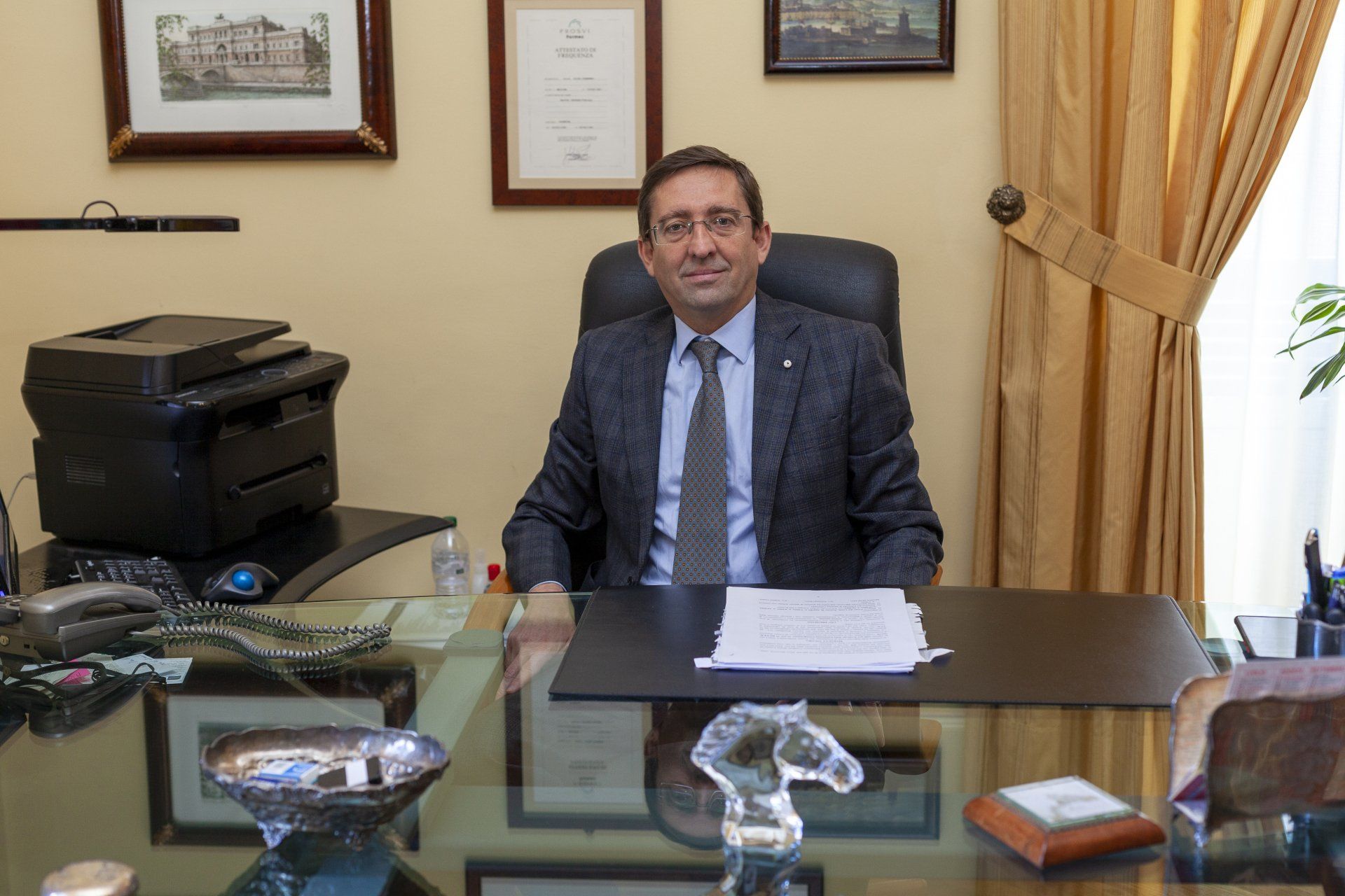 Un uomo in giacca e cravatta è seduto alla scrivania di un ufficio.