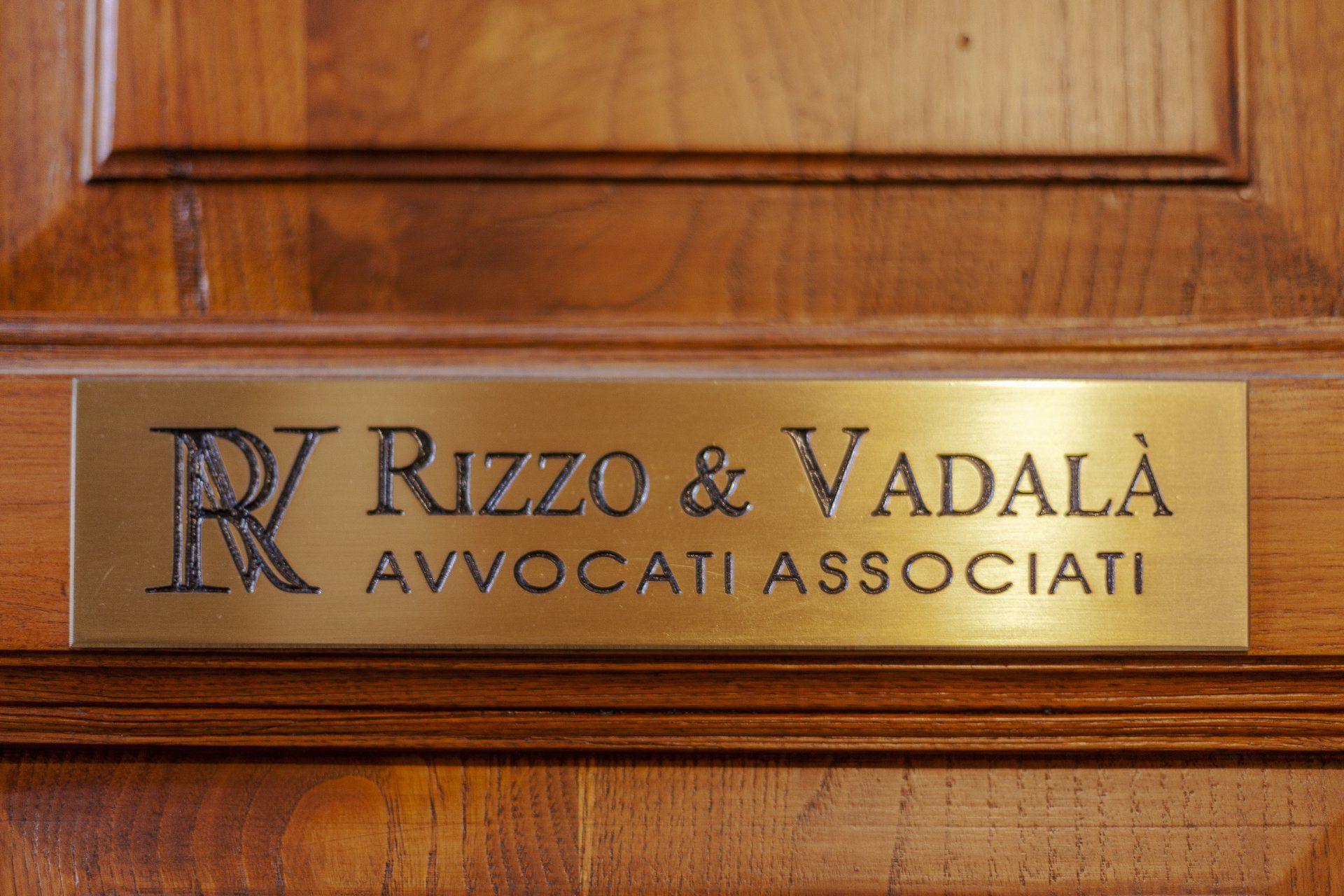 Brass nameplate on a wooden door: