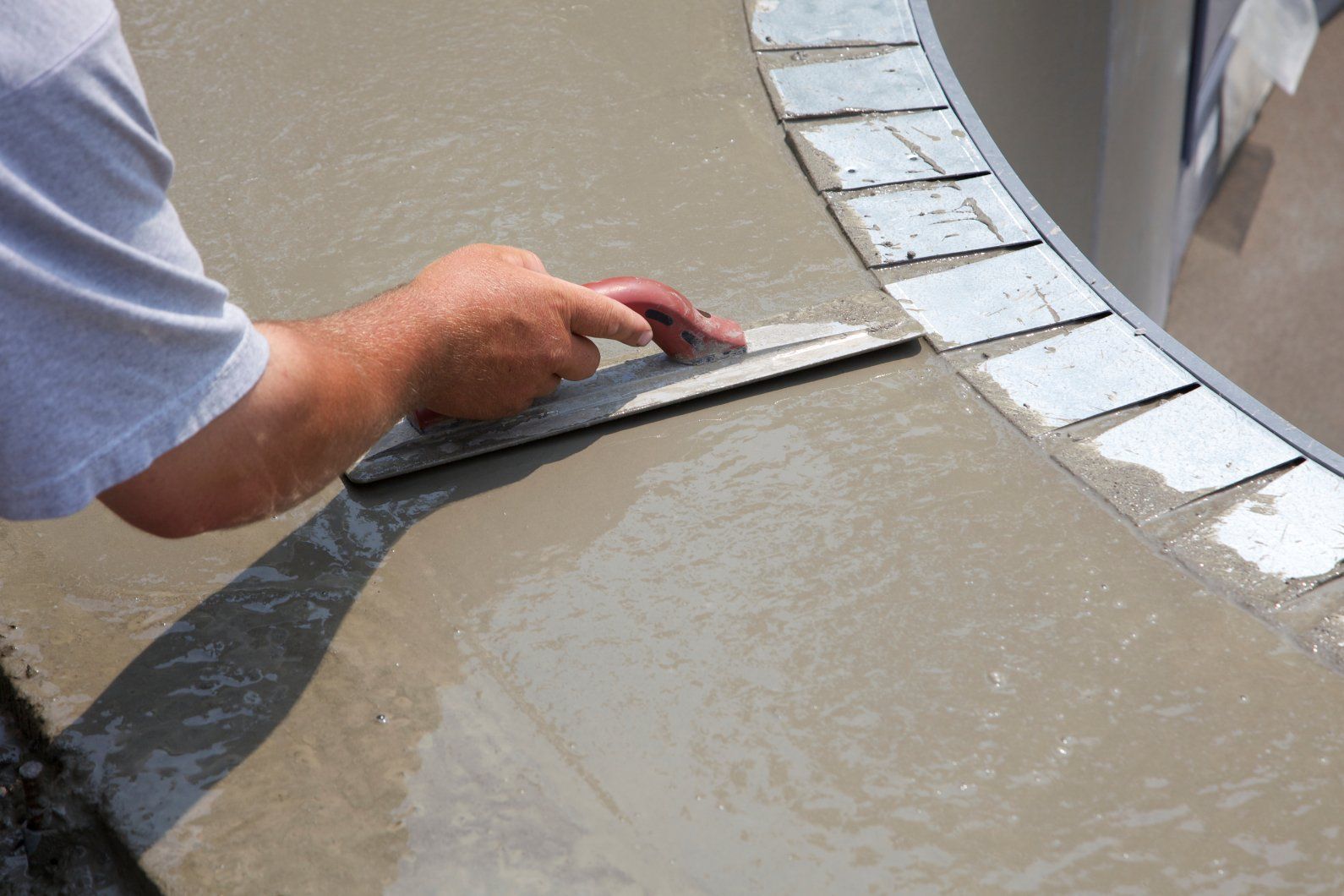 Peterborough concrete contractor putting the finishing touched on a concrete pool deck border.