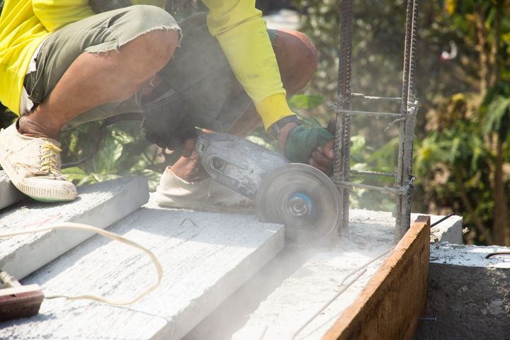 Peterborough concrete contractor installing concrete stairs.  He's cutting the edges to make them even.