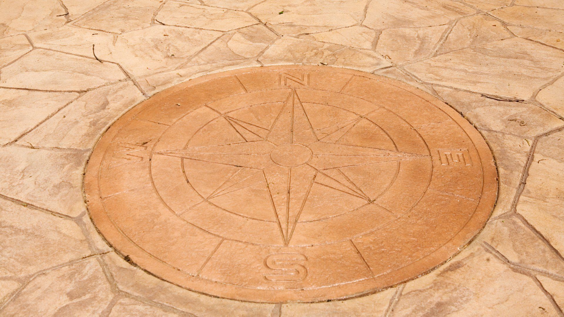 Concrete patio with a neat compass stamp design in the middle.