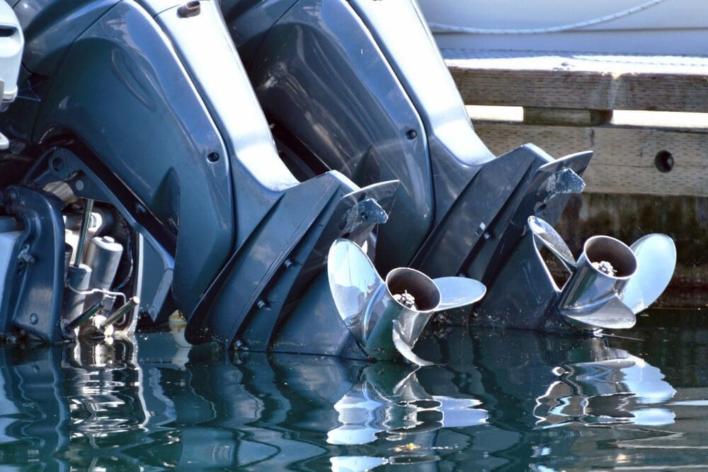 Two Outboard Motors Are Sitting in the Water Near a Dock — Whitsunday Diesel & Marine In Rockhampton, QLD