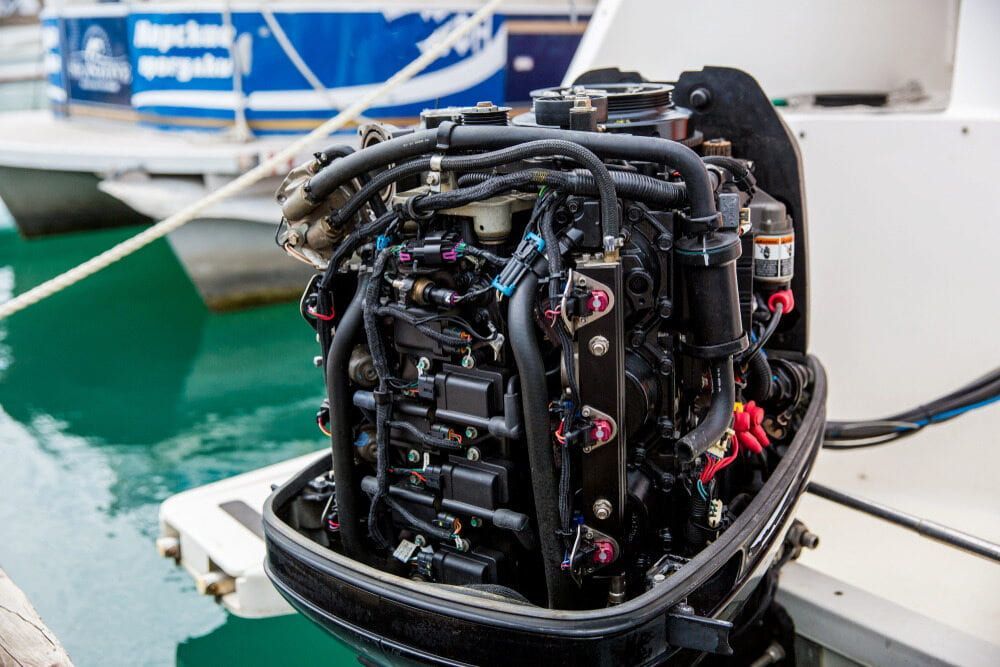 A Boat Engine is Sitting on the Side of a Boat — Whitsunday Diesel & Marine In Townsville, QLD