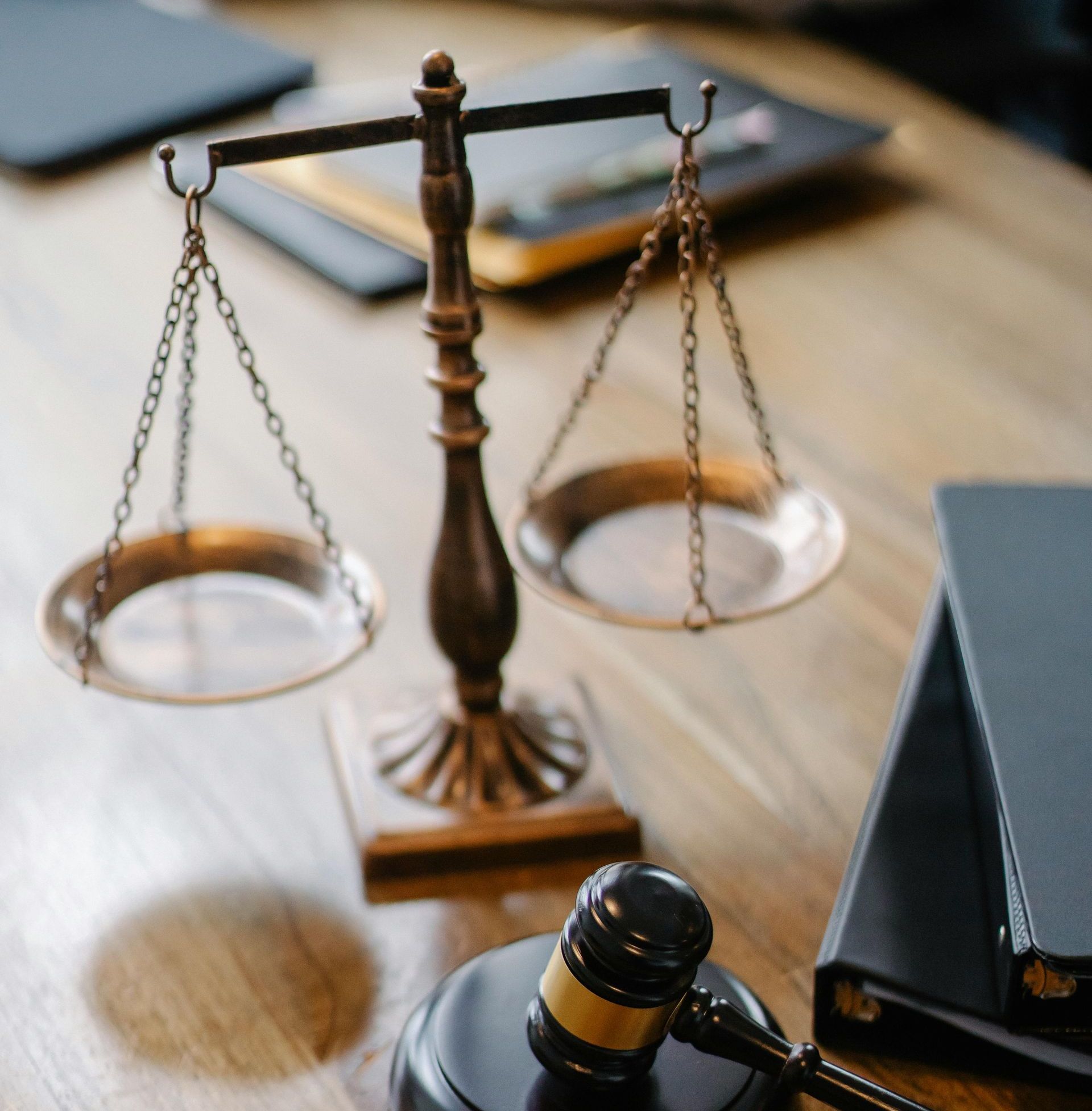 A scale and a gavel on a wooden table