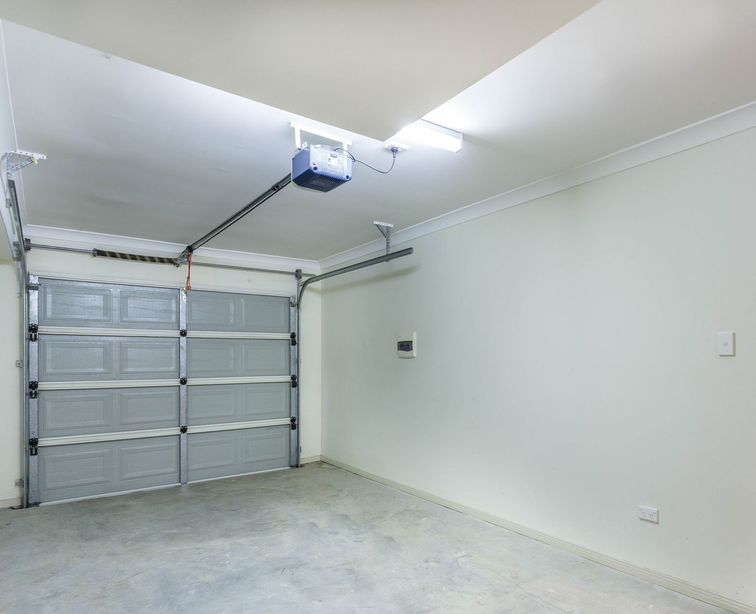 A person is fixing a garage door with a drill.