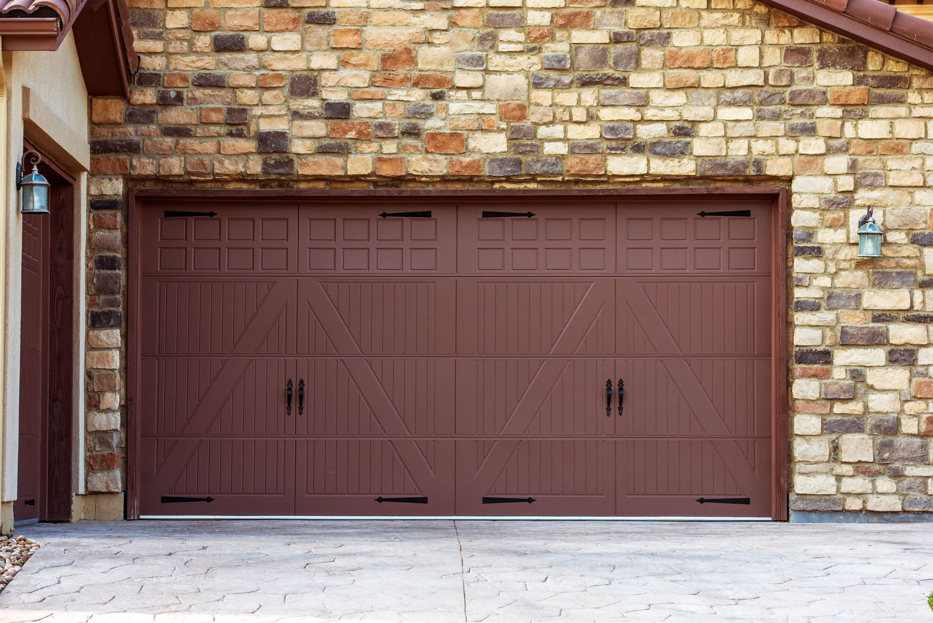 Brown garage door on a brick house with matching siding and a concrete driveway.