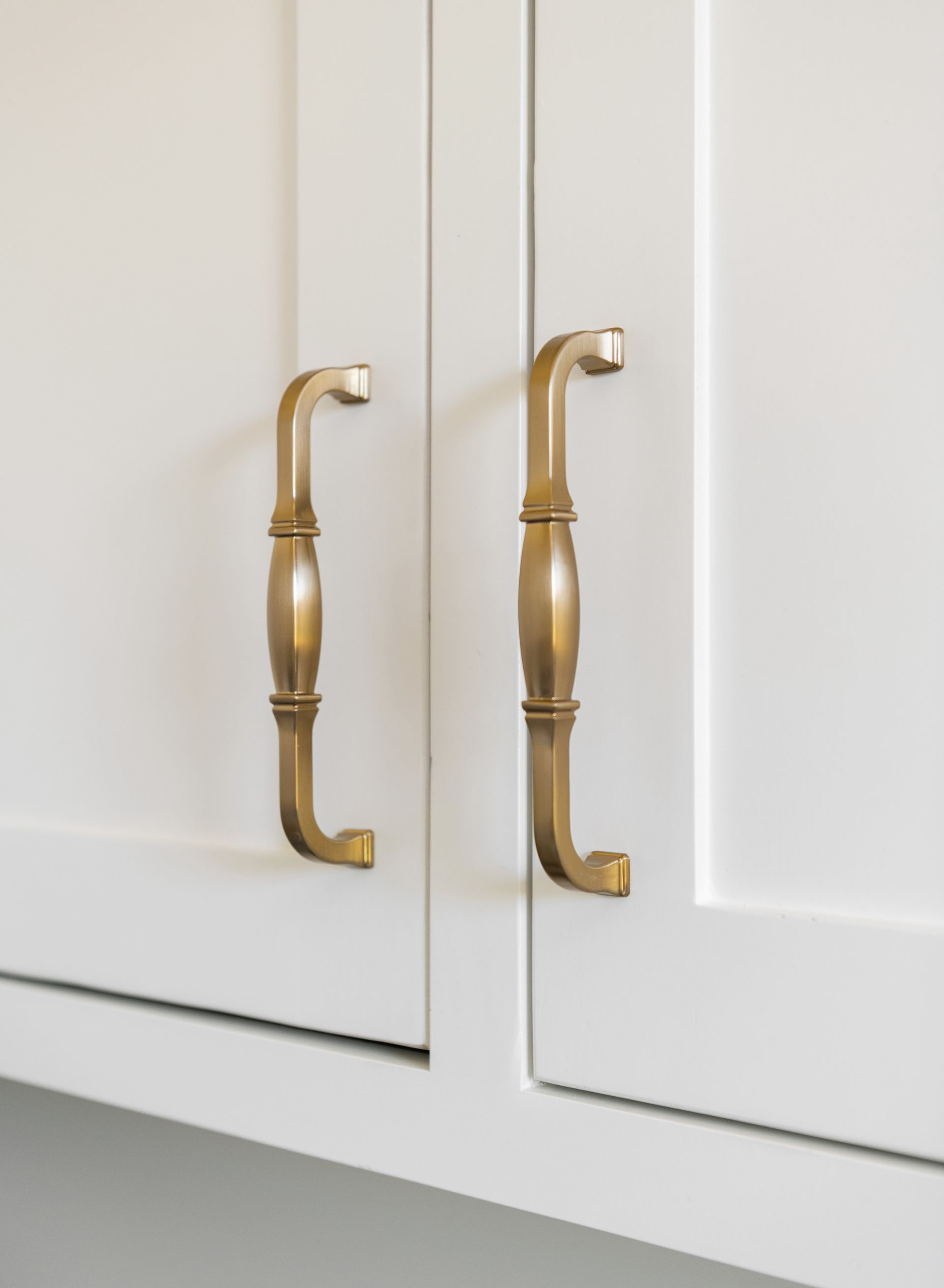 Brass handles on white cabinet doors