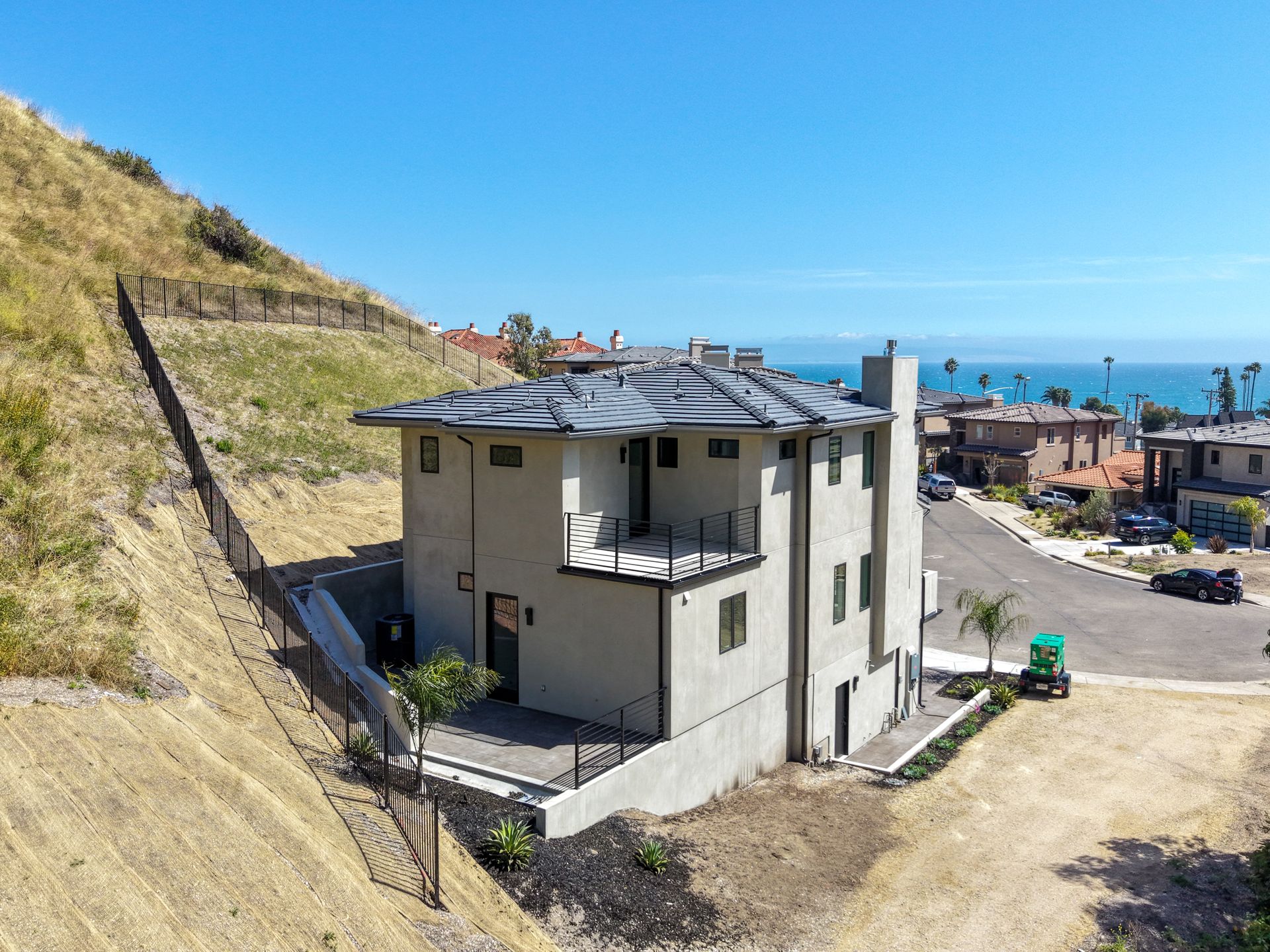 Coastal house on a hillside with ocean view and clear blue sky