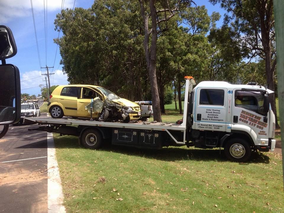 A Yellow Car is Being Towed by a Tow Truck — Hervey Bay Tilt Tray Hire In Takura, QLD
