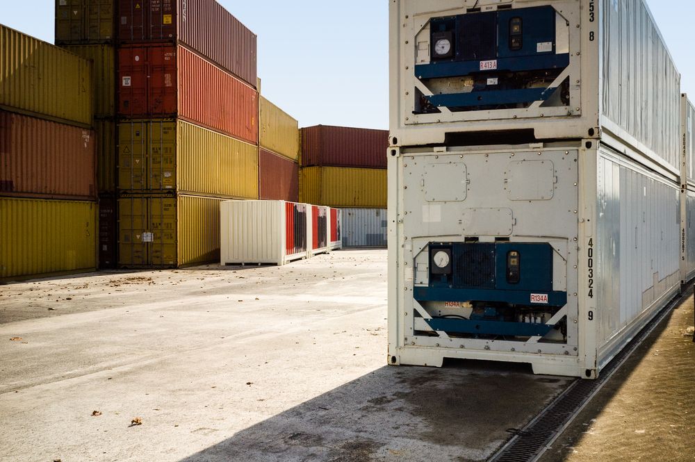 A Row of Shipping Containers Are Stacked on Top of Each Other in a Parking Lot — Hervey Bay Tilt Tray Hire In Takura, QLD