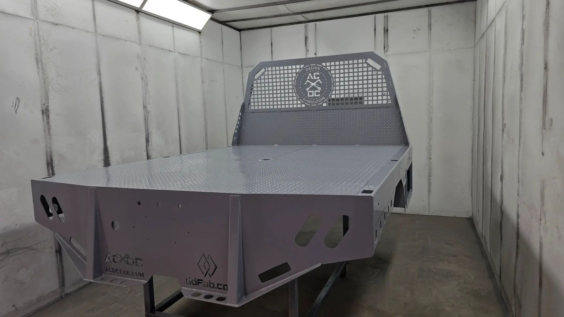 Industrial metal workbench with mesh back in a gray spray booth or room