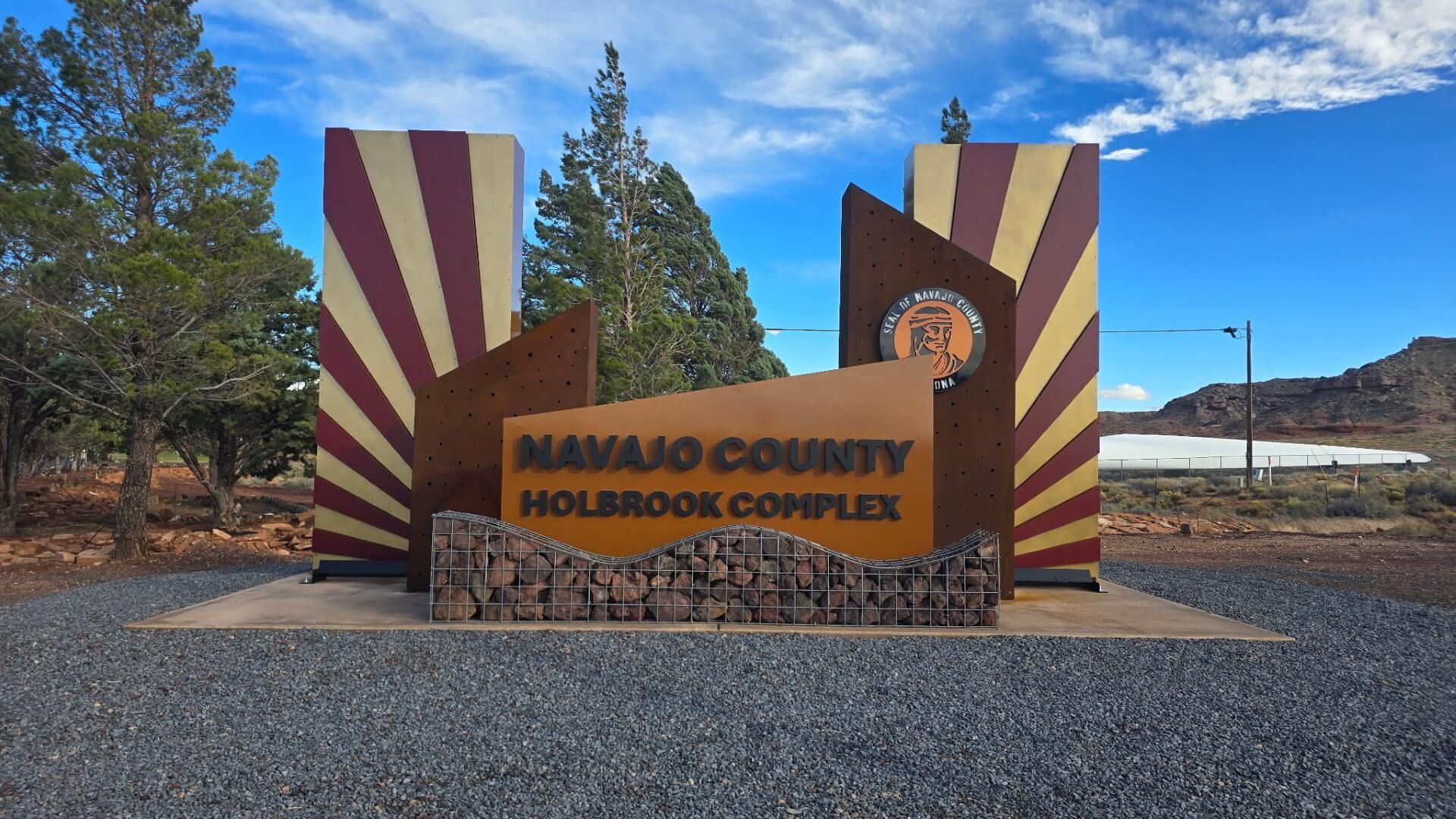 Holbrook town sign with sunburst pillars and courthouse seal in a desert roadside setting