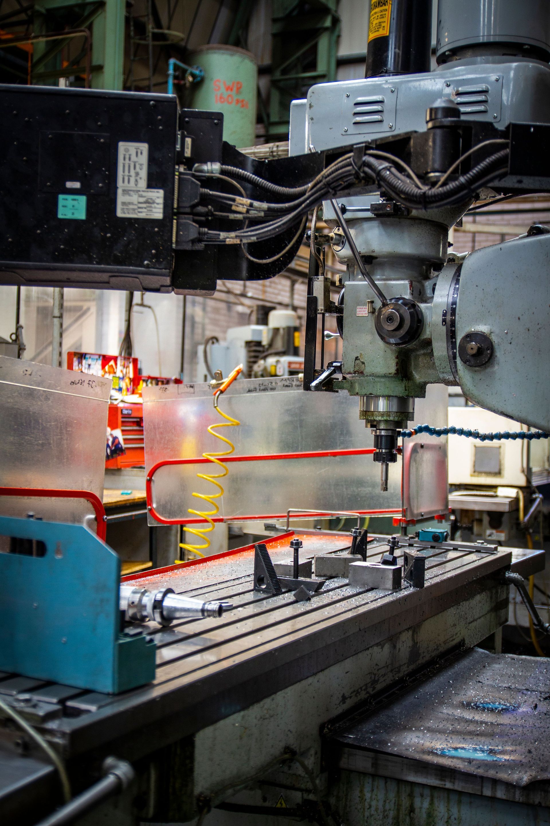 Industrial CNC machine cutting metal with orange sparks in a factory workshop