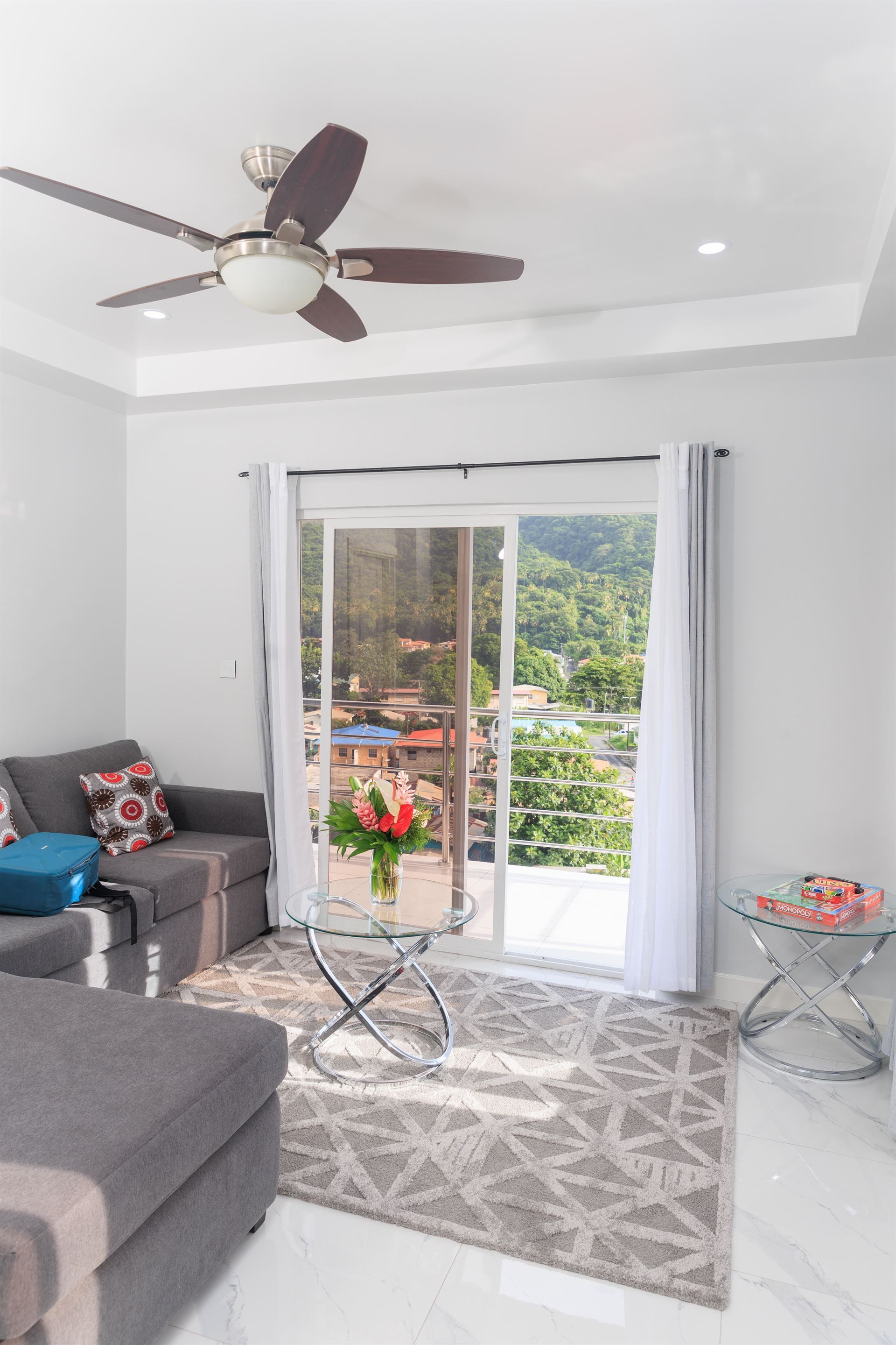 A living room with a sliding glass door and a ceiling fan.