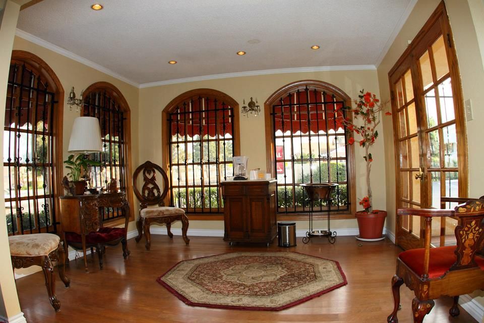 Elegant living room with arched windows, wooden furniture, and a central rug
