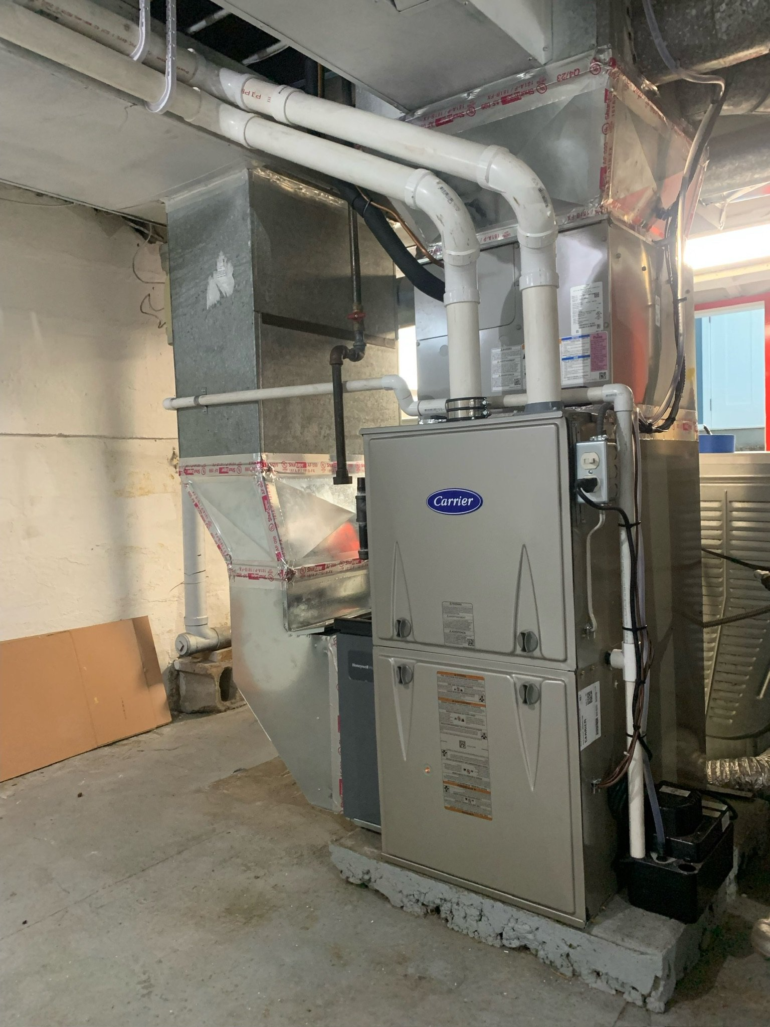 A large air conditioner is sitting in a room next to a window.