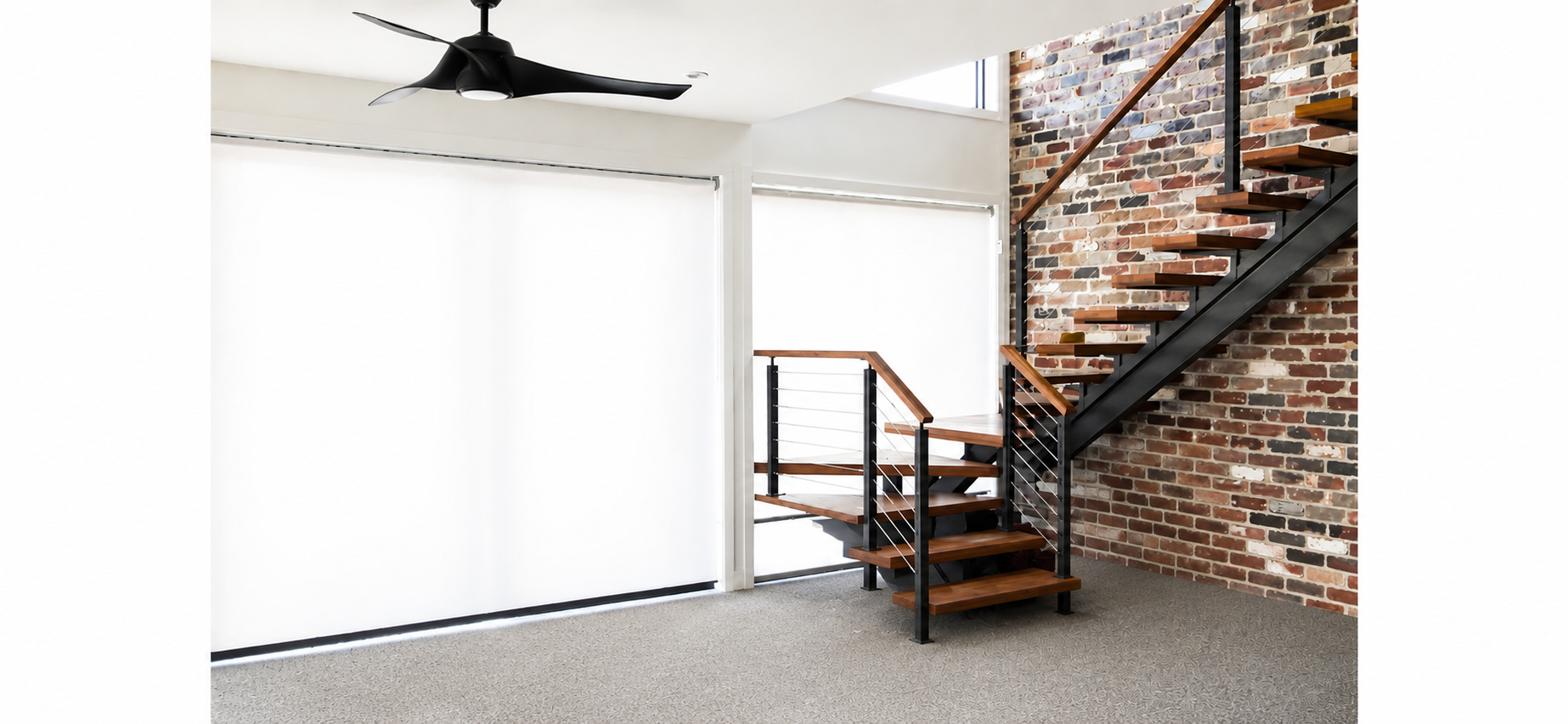 Modern loft interior with brick staircase, black railing, and large white wall panels