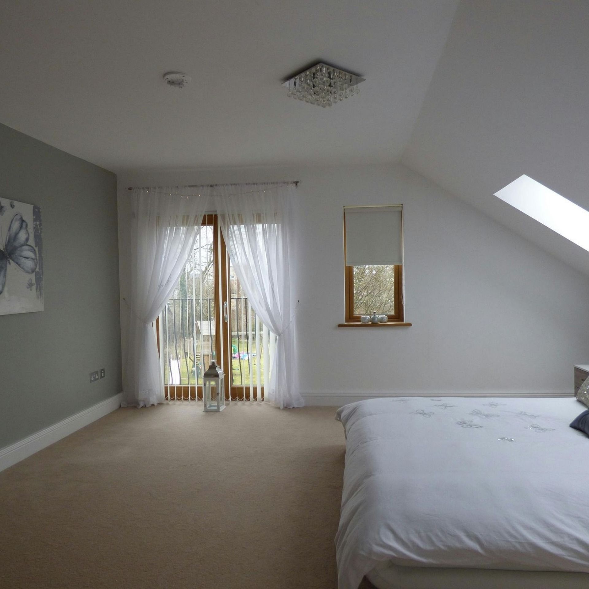 Bedroom interior with a skylight and neutral painted walls