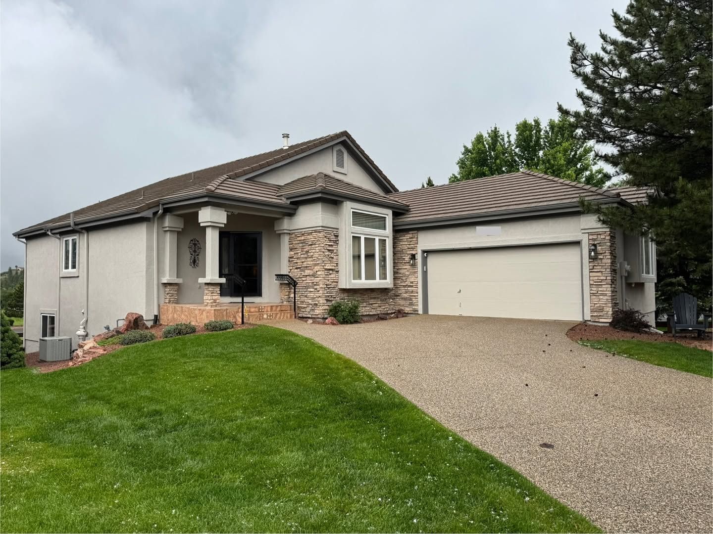 Completed Carroll Painting stucco coating project with cream walls and stone accents