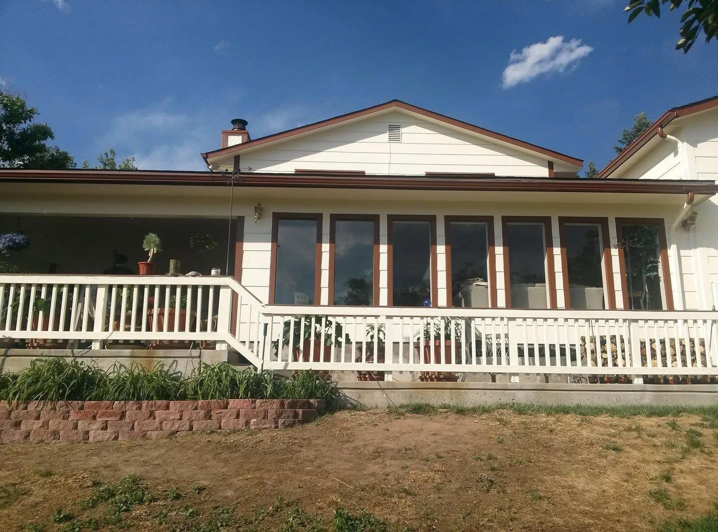 Completed exterior with white siding and brown garage door and trim