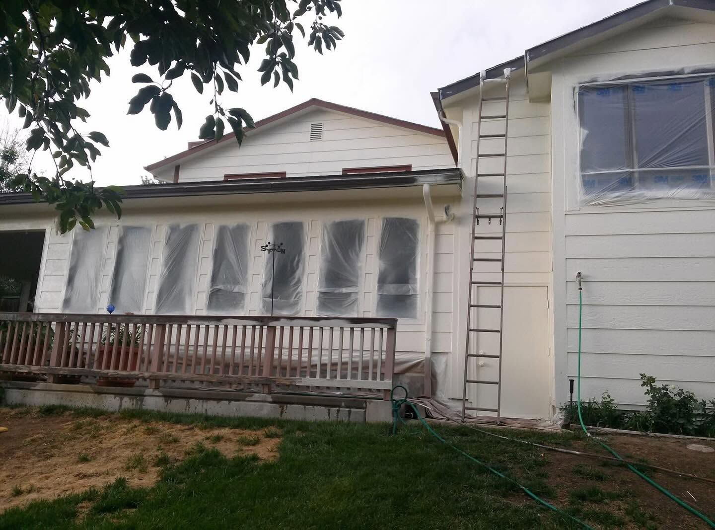 House exterior during preparation before white siding painting was completed