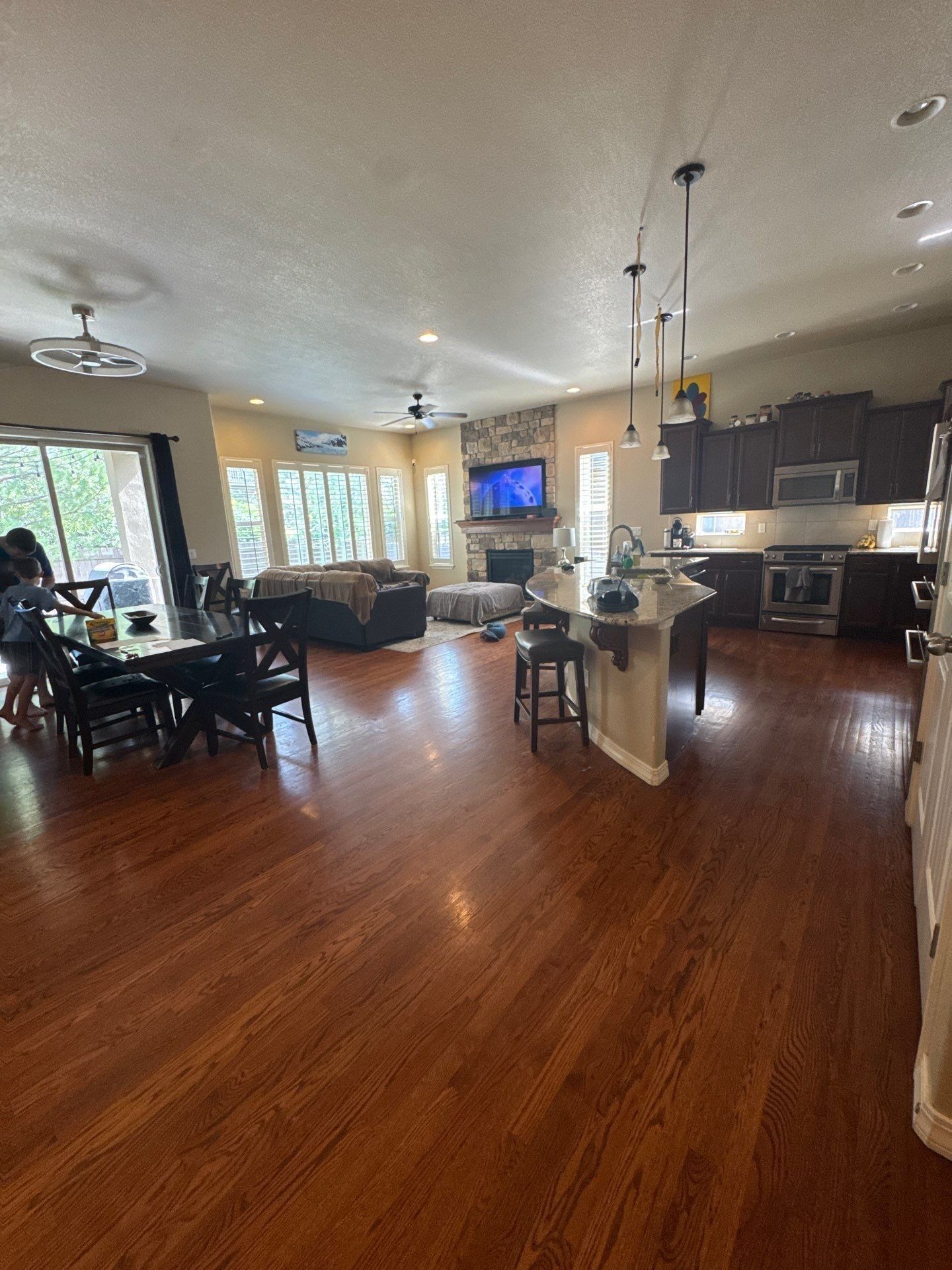 Connected kitchen dining and living spaces with wood flooring in the same Colorado Springs estimate