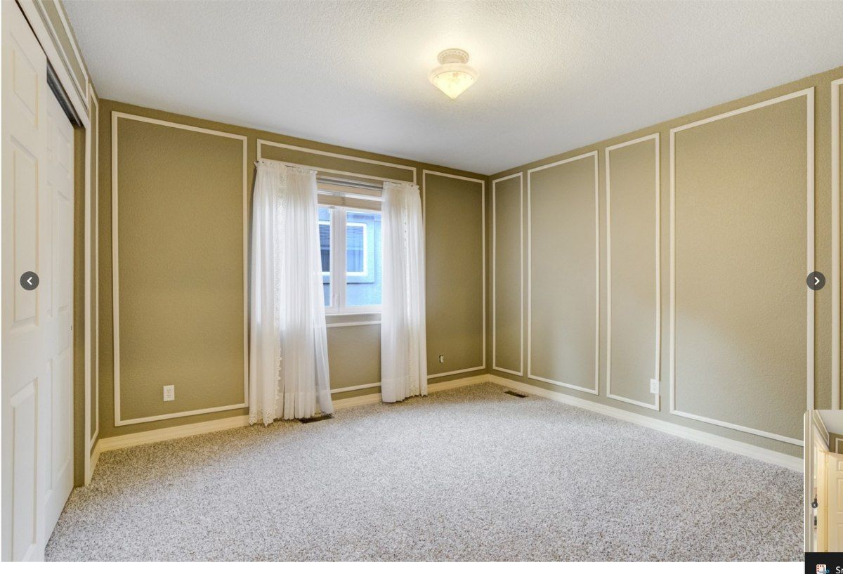 Upstairs bedroom with rectangular decorative wall mouldings before the proposed removal