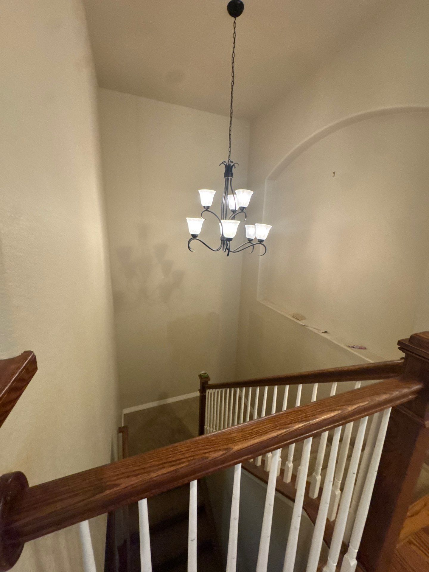 Tall stairwell walls beside a wood handrail in the Colorado Springs foyer painting estimate