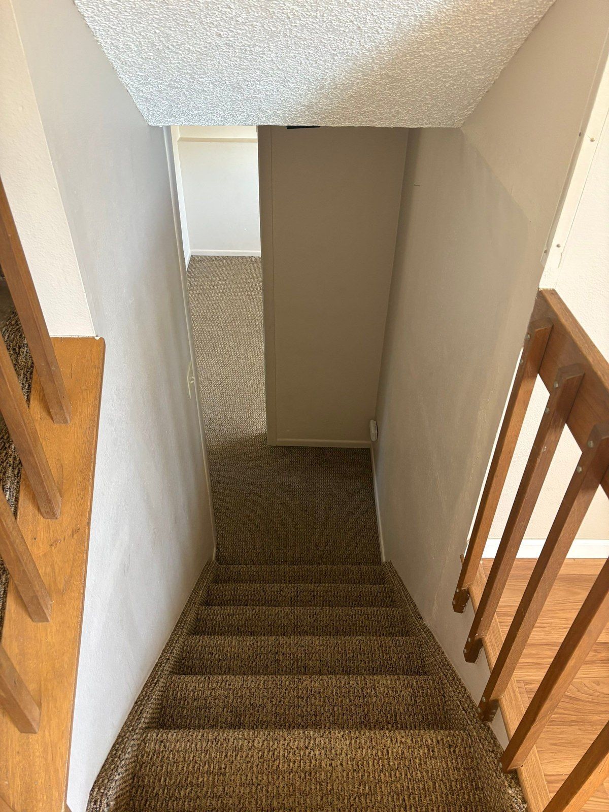 Stairway walls, steps and a retained wood railing photographed for the same interior proposal