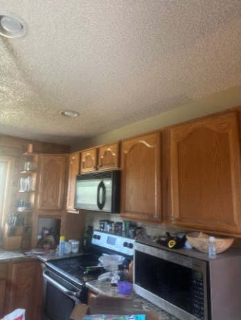 Existing kitchen wall and ceiling beside wood cabinets in the Elbert estimate