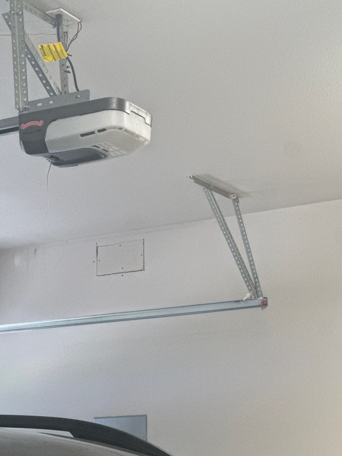Existing garage ceiling with garage-door motor, rail hardware and a rectangular panel in the same Colorado Springs painting estimate