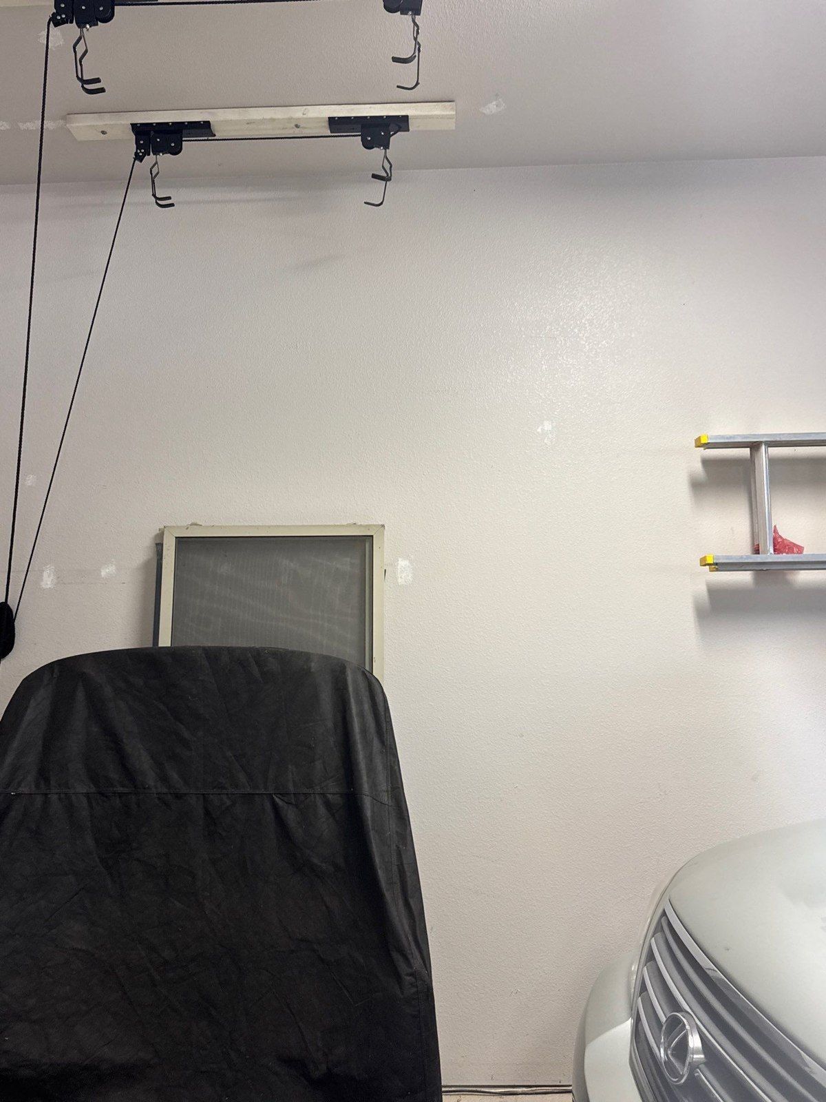 Existing garage wall and opening beside a covered stored item and part of a vehicle in a Colorado Springs estimate