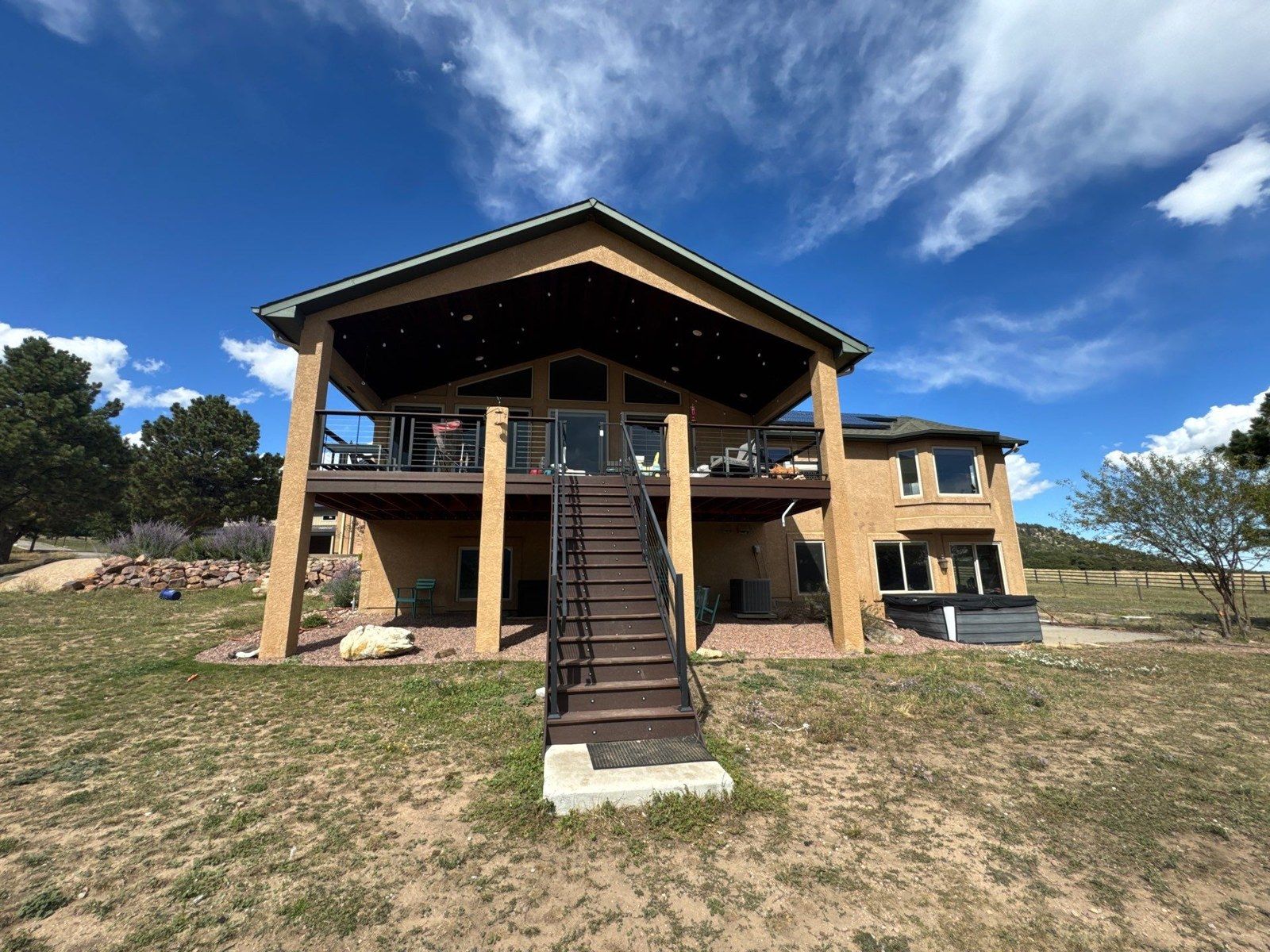 Existing covered rear porch, elevated deck, stairs and stucco walls in the same Larkspur proposal