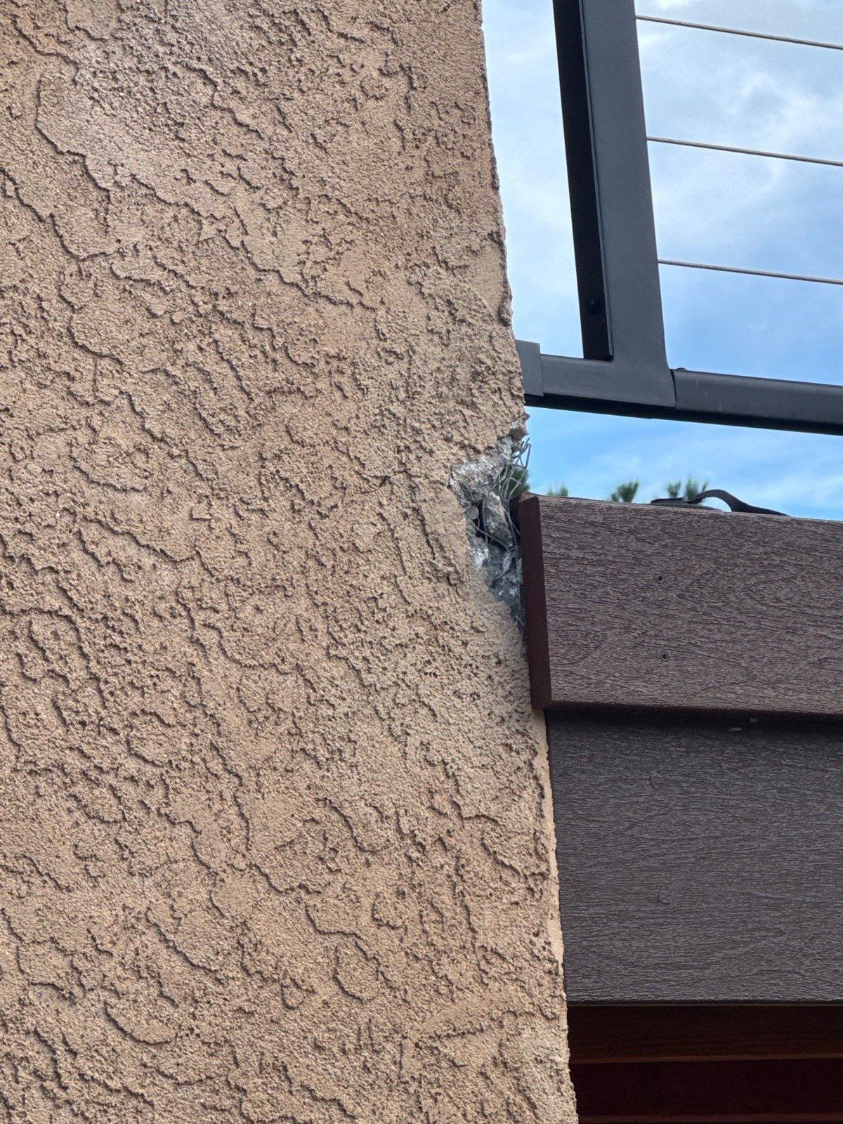 Close-up of existing textured stucco beside a painted exterior component in the same Larkspur estimate