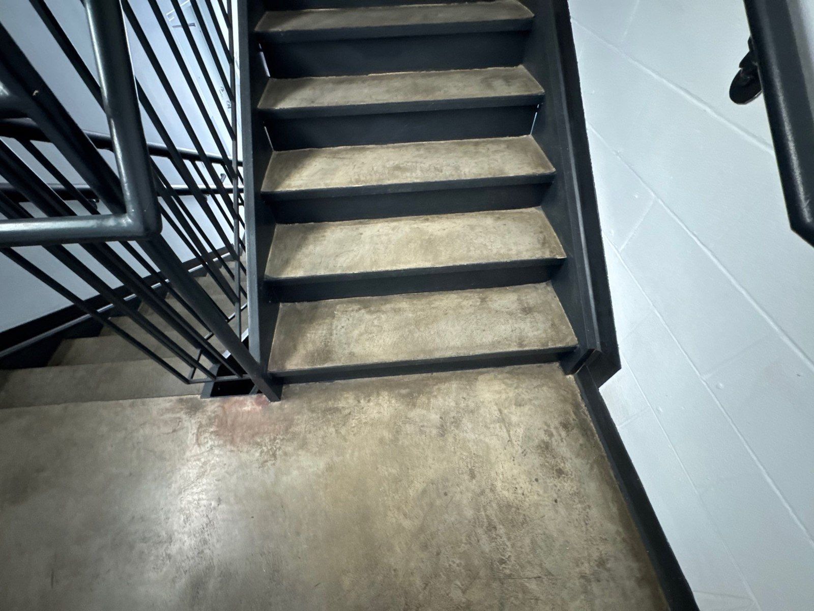Existing stair treads and landing beside railings in the same Monument floor epoxy proposal