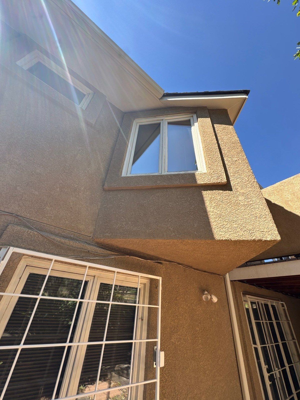 Upper window with a projecting stucco surround above the patio area at the same Monument property