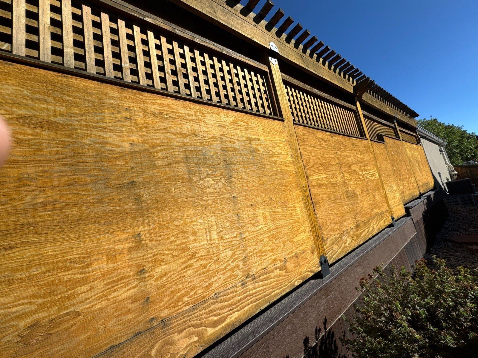 Existing privacy wall with lattice and broad side panels beside the pergola in the same project