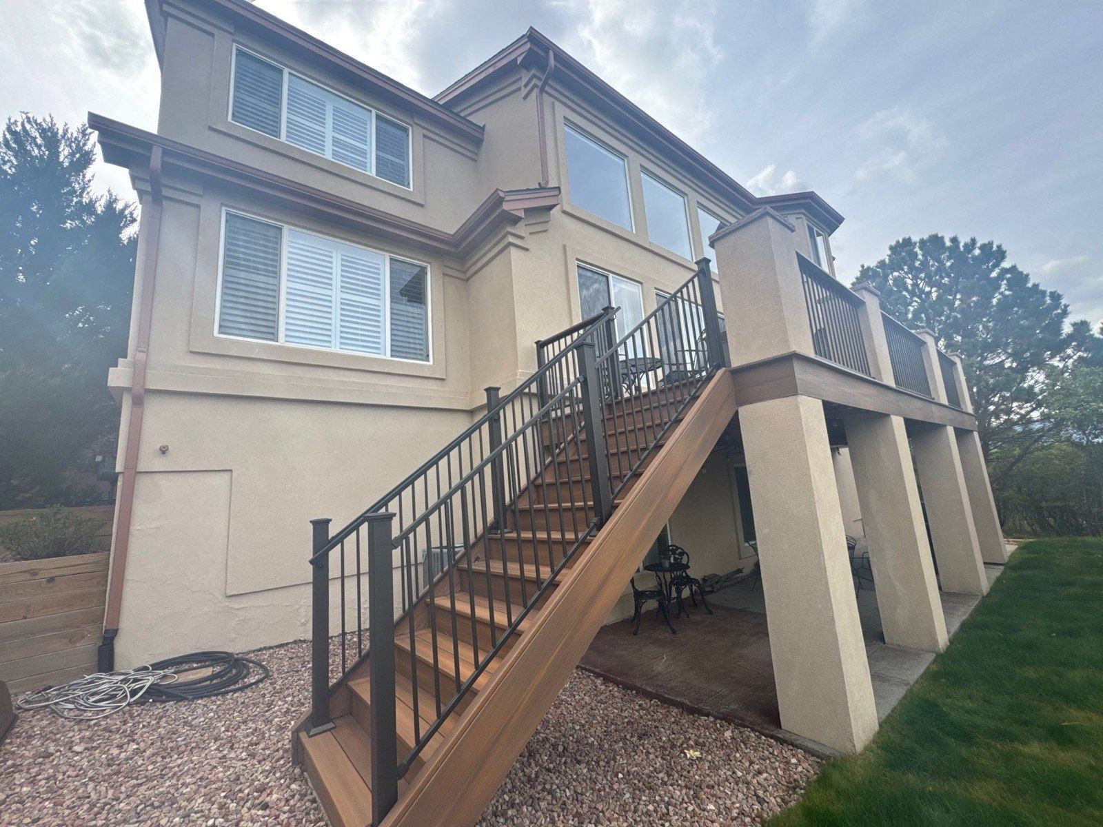 Existing rear stucco walls beside elevated deck and exterior stairs in the same Colorado Springs proposal