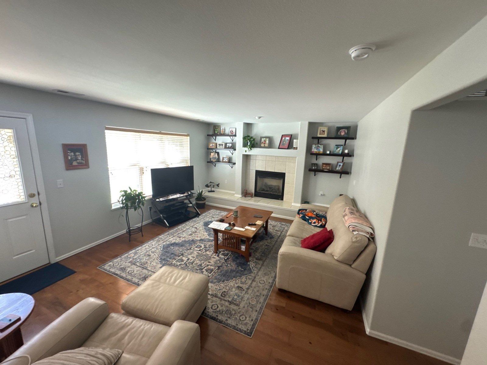 Existing living room with painted walls, ceiling, light trim, seating and retained wood flooring in the same Colorado Springs estimate