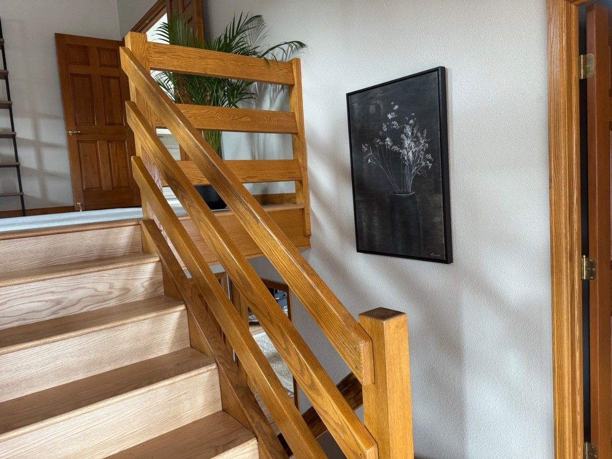 Wood stair railing beside carpeted steps in the same Colorado Springs interior estimate