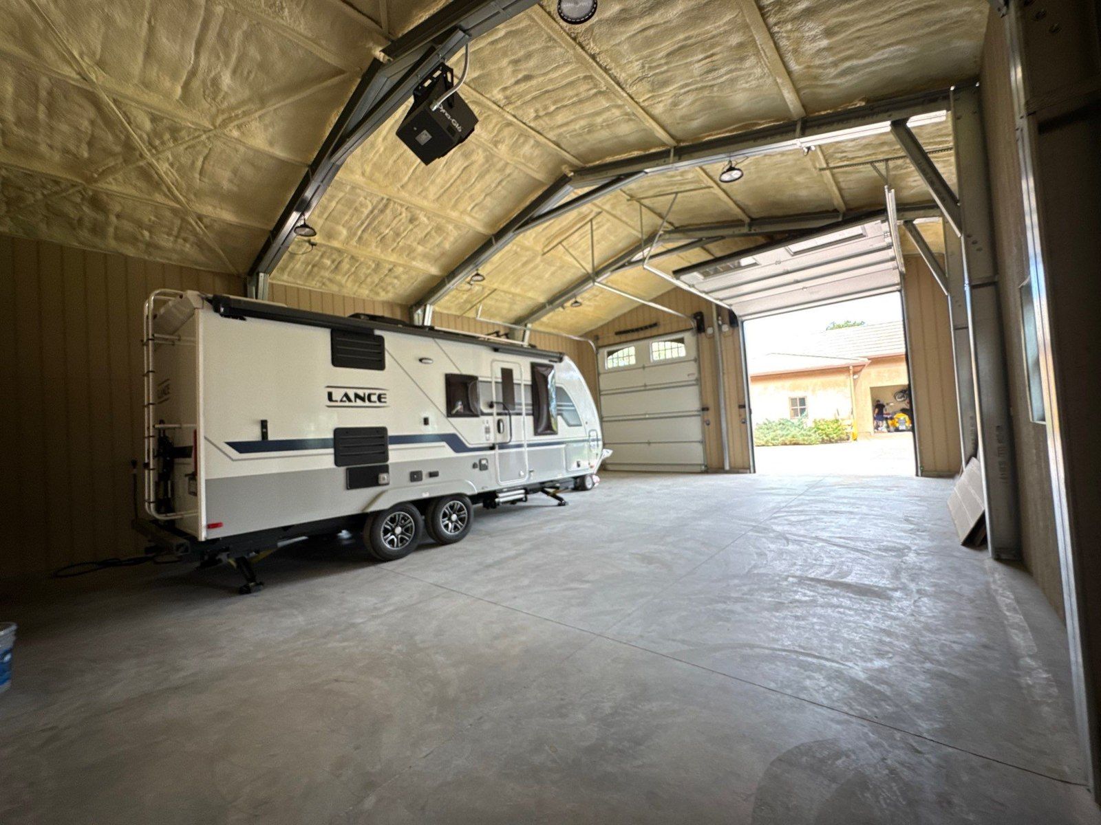 Workshop walls, overhead structure and concrete floor beside a recreational vehicle in a Colorado Springs estimate