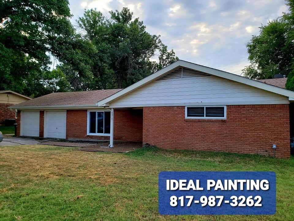 Single-story red brick house with white trim and garage, with “Ideal Painting” contact sign in front.