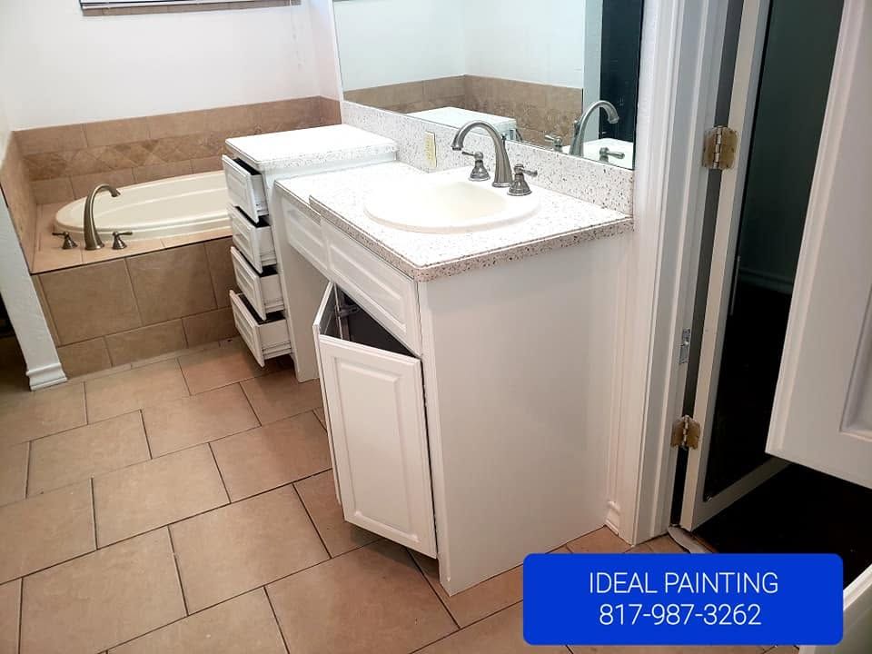 Bathroom with tan tile, white vanity, sink, mirror, and built-in tub, labeled “Ideal Painting” at bottom right